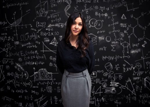 Woman standing in front of a blackboard with calculations