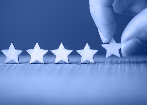 Five stars and a hand placing the fifth star in a row