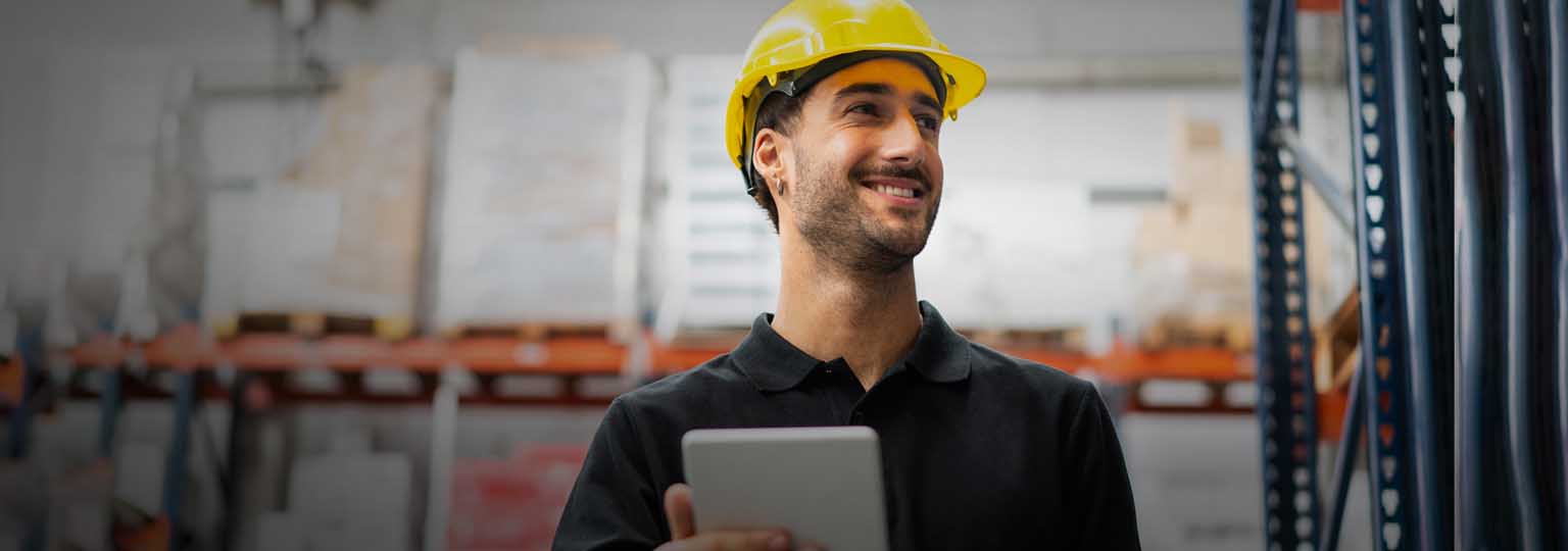Man in hard hat happily working in warehouse