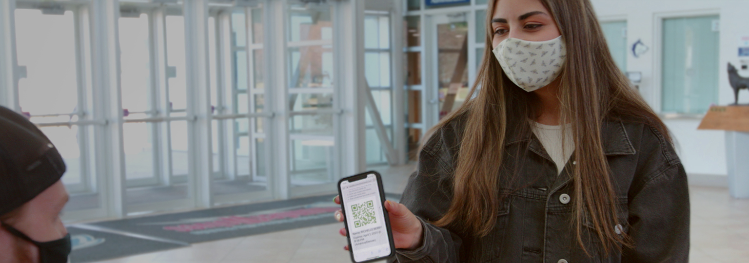 College student with mask showing phone app