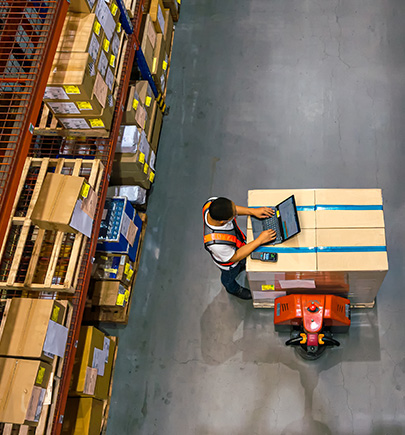 overhead view of man working on laptop in warehouse