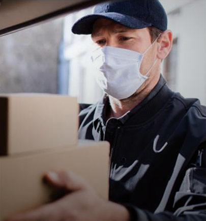 delivery man wearing a mask holding packages