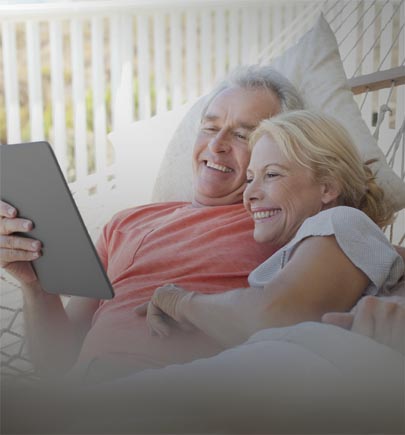 mature-couple-on-hammock-viewing-tablet