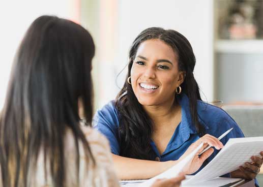 Smiling confident female financial advisor works with client